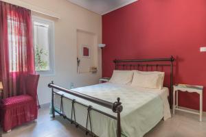 雅典的住宿－Casa Bonita, House with Private Entrance and Garden, between center and sea，一间卧室设有一张床和红色的墙壁