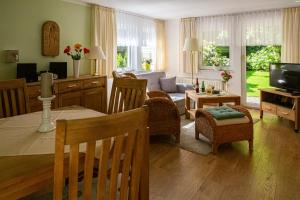 ein Wohnzimmer mit einem Tisch und ein Wohnzimmer mit einem Sofa in der Unterkunft Ferienhaus Giesela **** in Wernigerode