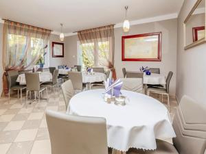 une salle à manger avec des tables et des chaises blanches dans l'établissement Willa Luna, à Władysławowo