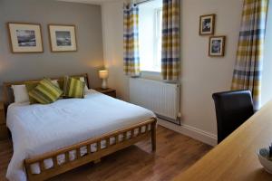 a bedroom with a bed and a table and a window at The Angel Hotel in Cardigan