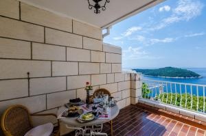 balcón con mesa y vistas al océano en Apartments Cicko en Dubrovnik
