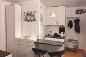 eine Küche mit weißen Schränken und schwarzen Arbeitsplatten in der Unterkunft Studio apartman Bruno in Zagreb