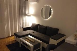 ein Wohnzimmer mit einem Sofa und einem Spiegel in der Unterkunft Studio apartman Bruno in Zagreb