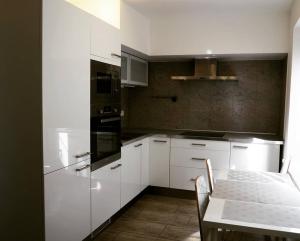 eine Küche mit Küchengeräten, einem Tisch, einem Tisch und einem Tisch in der Unterkunft Apartmán 224 in Mikulov