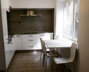 a kitchen with white cabinets and a table and chairs at Apartmán 224 in Mikulov