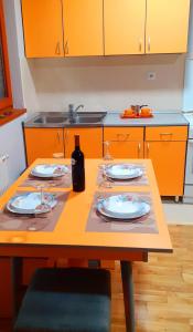 een keuken met een tafel met borden en wijnglazen bij IDI MI - DODJI MI in Vrnjačka Banja
