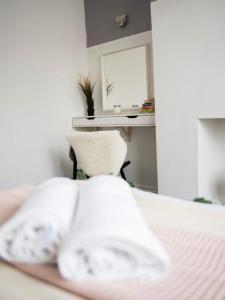 a bedroom with a bed with white pillows and a mirror at Buchanan House Sasco Apartments in Blackpool