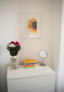 Un tocador blanco con un jarrón de flores. en Buchanan House Sasco Apartments, en Blackpool
