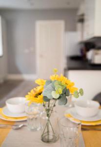 een vaas gevuld met gele bloemen zittend op een tafel bij Buchanan House Sasco Apartments in Blackpool