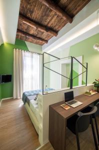 una camera con letto e scrivania con computer portatile di Mediterra a Castellammare di Stabia
