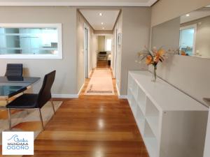 a hallway with a table and a vase of flowers at Apartamento Ogoño in Mundaka
