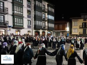 a group of people walking down a street with a crowd at Apartamento Ogoño in Mundaka