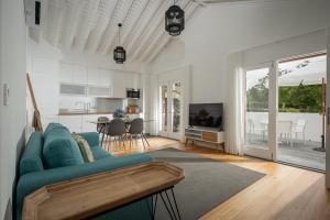 a living room with a blue couch and a kitchen at Quinta dos 10 in Ponta Delgada