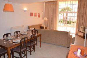 - un salon avec une table à manger et un canapé dans l'établissement Ponta Grande Sao Rafael Resort by Umbral, à Albufeira