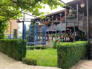 a garden with a swing in front of a building at Casa Ciobi in 2 Mai
