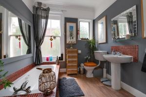 uma casa de banho com uma banheira e um lavatório em Eclectic Dreams em Portsmouth
