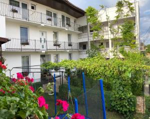 a building with flowers in front of it at Casa Ciobi in 2 Mai