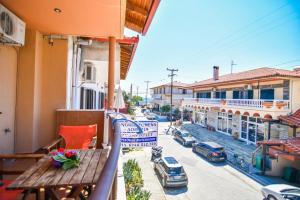 a balcony with a wooden bench and a city street at House Chrysoula Mitsokopi in Sarti