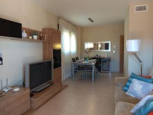 a living room with a couch and a tv and a table at Apartamento cerca playa San Juan in Alicante