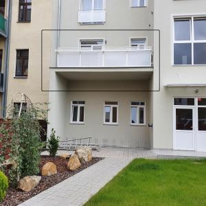 an apartment building with a balcony and a yard at Apartments Oberschlesien in Görlitz
