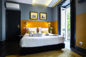 リスボンにあるSanta Luzia B&B - HOrigemのベッドルーム1室(白いシーツと黄色い枕の大型ベッド1台付)