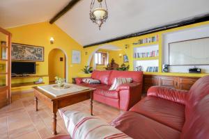un soggiorno con divano rosso e tavolo di Villa Casa Concha a Teguise