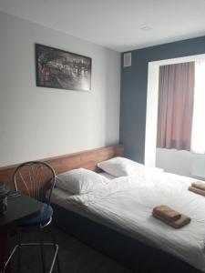 Schlafzimmer mit einem Bett, einem Tisch und einem Fenster in der Unterkunft Новая и уютная квартира в центре in Uschhorod