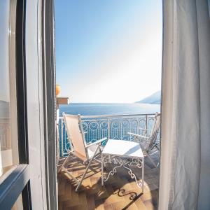 een balkon met stoelen en uitzicht op de oceaan bij Hotel Club Due Torri in Maiori