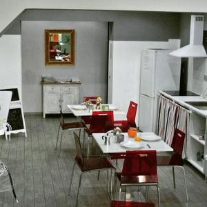 a kitchen with a table and red chairs in a kitchen at My Room Roma in Lido di Ostia