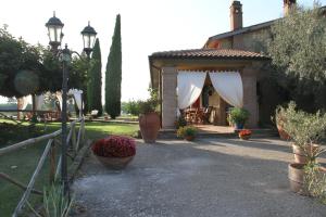 um pavilhão com um dossel branco num jardim em A Casa di Amici em Tuscania