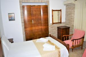 a bedroom with a bed and a table and a door at Evaggelou Rooms in Potos