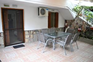 a table and chairs in front of a building at Evaggelou Rooms in Potos