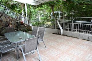 a patio with a table and chairs and a fence at Evaggelou Rooms in Potos