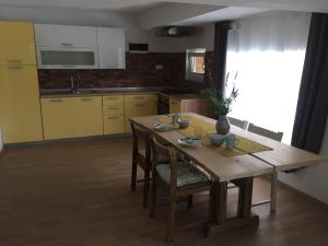 a kitchen with a wooden table with chairs and a dining room at Hillside Bio Resort Apartment with Mountain View in Prebold