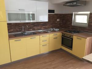 a kitchen with yellow cabinets and a sink at Hillside Bio Resort Apartment with Mountain View in Prebold