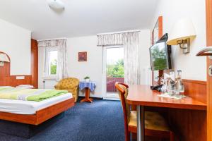 een hotelkamer met een bed en een bureau bij Landhotel Georgshof in Hünfeld