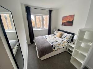 Un dormitorio pequeño con una cama y un espejo. en Bridlington Bay Apartments, en Bridlington