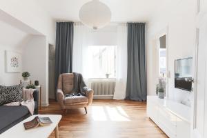a living room with a couch and a tv at Cozy Apartment in Uppsala