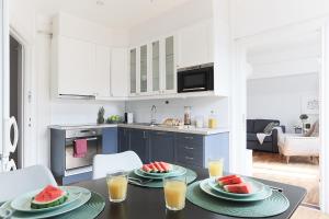 a kitchen with a table with two plates of watermelon at Cozy Apartment in Uppsala