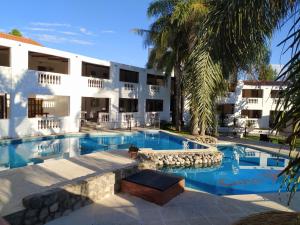 a swimming pool in front of a building at Cana Blaya Apart Hotel in Merlo