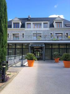 un gran edificio con plantas delante en Domitys Le Parc de Vinci, en Amboise