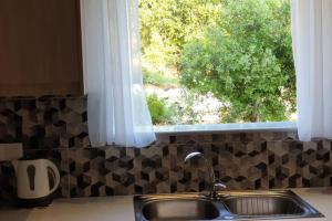 un lavello da cucina con una finestra sopra un bancone di Villa Rania Loutraki a Loutraki Altre 16 foto