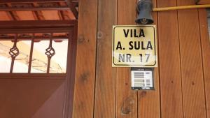 a sign on the side of a wooden building at Vila Sula Guesthouse in Durrës