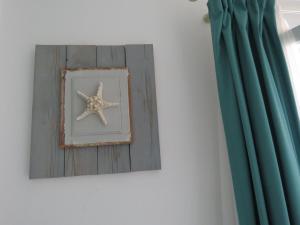 a starfish in a picture in a frame next to a curtain at Corali Hotel Beach Front Property in Ios Chora