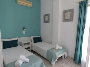 Duas camas num quarto com paredes azuis em Corali Hotel Beach Front Property em Chora, Ios