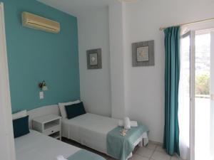 a room with a bed and a couch and a window at Corali Hotel Beach Front Property in Ios Chora