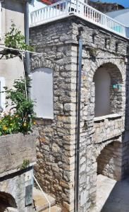 eine Steinmauer mit einem Balkon darüber in der Unterkunft House Stone house Mia casa in Stari Grad