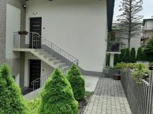 una scala che conduce a un edificio con alberi verdi di Apartamenty ,,Trzy Sosny'' Rymanów-Zdrój a Rymanów-Zdrój