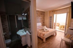 a bathroom with a bed and a sink and a mirror at La Perla Del Tirreno in Tropea