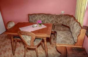 a wooden table and chairs with a table and flowers on it at Pie Pifa in Pāvilosta